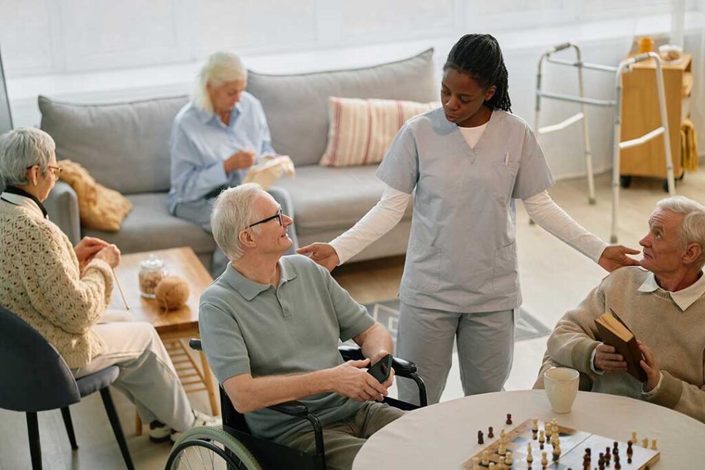 Senior resident using a magnifier beside a well-lit table in an organized assisted living room.