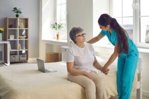 An older adult discussing care options with a family member at a kitchen table with paperwork and a cup of tea.